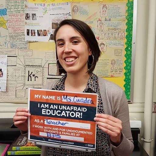 Natalia holding a sign that says she is an educator with Boston Public Schools